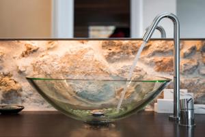 a glass bowl sitting on a counter with a faucet at Ambassadors Residence Boutique Hotel in Chania Town