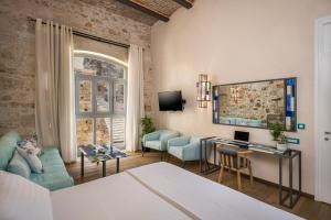 a room with a bed and a desk with a computer at Ambassadors Residence Boutique Hotel in Chania