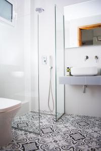 a bathroom with a glass shower and a sink at Avgerou Studios and Apartments in Psakoudia