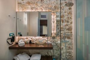 a bathroom with a sink and a shower with a mirror at Ambassadors Residence Boutique Hotel in Chania Town
