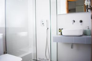a white bathroom with a sink and a shower at Avgerou Studios and Apartments in Psakoudia