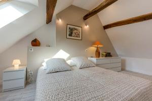 a bedroom with a bed with a white bedspread at Beaune Sweet Home in Beaune