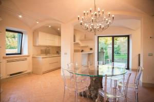 une cuisine et une salle à manger avec une table et des chaises en verre dans l'établissement Villa Casupoli, à Castiglion Fiorentino