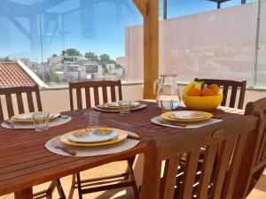 a wooden table with a bowl of fruit on it at Alvor Terrace Villa in Alvor