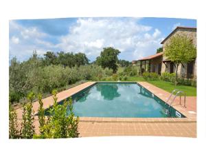 a swimming pool in the yard of a house at Casa Gioiello in Castiglione del Lago
