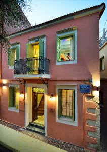 a pink house with a balcony on a street at Casa della Favola Boutique Hotel in Chania