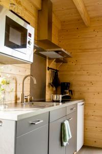 a kitchen with a sink and a stove top oven at Camping Nieuw Romalo in Voorthuizen