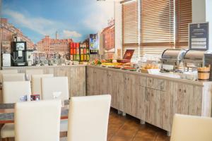 un ristorante con un bancone con sedie bianche di Hotel Gordon a Varsavia