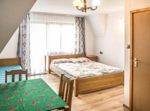 a small bedroom with a bed and a table at U Bochniaka in Czorsztyn