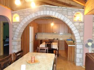 cocina y comedor con mesa y arco en Menina Farm Kalamata Countryside en Perivolákia