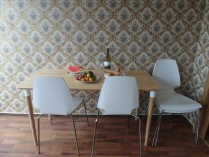a dining room table with white chairs and a bowl of fruit at Sympathisches Retro Apartment in Offenbach +31 photos