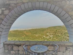 an arch in a wall with a table and chairs at Menina Farm Kalamata Countryside in Perivolákia