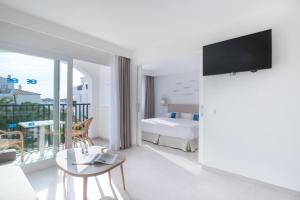 a hotel room with a bed and a balcony at FERGUS Style Carema Beach in Cala en Bosc