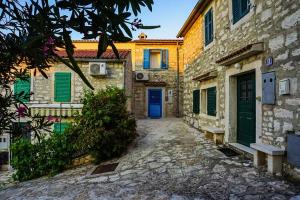 een steegje met een blauwe deur en enkele gebouwen bij Vila Vinci 1906 in Vrsar