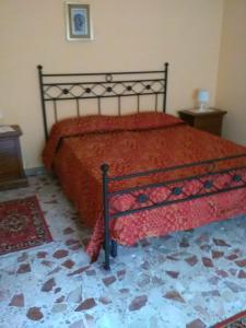 a bedroom with a bed with a red comforter at B&B Misatere in Vallelonga