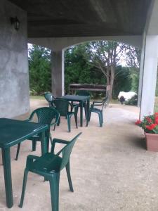 un ensemble de tables et de chaises vertes sur une terrasse dans l'établissement B&B Misatere, à Vallelonga