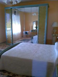 a bedroom with a large bed with a glass wall at B&B Misatere in Vallelonga