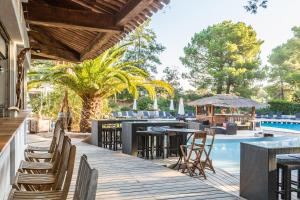 een terras met tafels en stoelen naast een zwembad bij Kilina in Porto-Vecchio