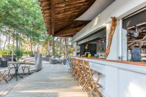 een bar op een patio met tafels en stoelen bij Kilina in Porto-Vecchio