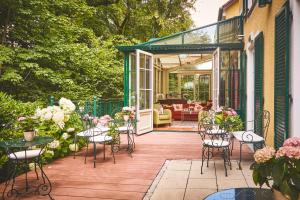 a patio with tables and chairs on a house at Hotel Freisinger Hof in Munich