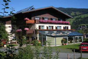 a large house with flowers on the top of it at Wellness Pension Hollaus in Kirchberg in Tirol