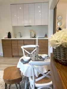 a kitchen with a table and white cabinets at Jelena103 Tatranska Lomnica in Tatranská Lomnica +3 photos