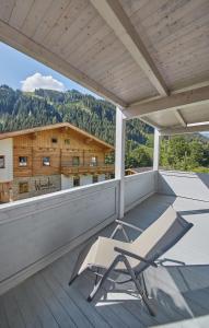 a white chair sitting on the balcony of a house at Chalet Birkenhof in Saalbach Hinterglemm