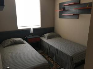 2 camas individuales en una habitación con ventana en Laguna Bahía Algarrobo, en Algarrobo