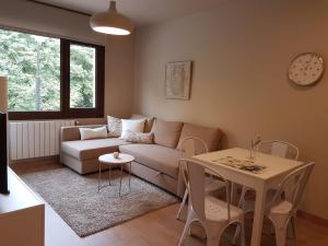 - un salon avec un canapé et une table dans l'établissement Apartamentos La Senda de Llanes, à Llanes