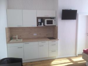 アイゼナハにあるEisenach - Apartmentsのキッチン(白いキャビネット、電子レンジ付)
