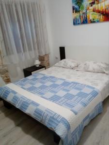 a bedroom with a bed with a blue and white comforter at Apartment Elena in Bale