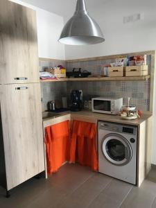 eine Küche mit einer Waschmaschine und einer Mikrowelle in der Unterkunft Casa nostra b&b in Porto Cesareo