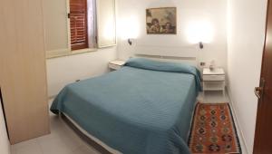 um pequeno quarto com uma cama azul e uma janela em Casa Giummarra al primo piano em San Vito lo Capo