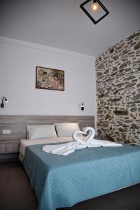 - une chambre avec un lit et un mur en pierre dans l'établissement Villa Anna, à Balíon