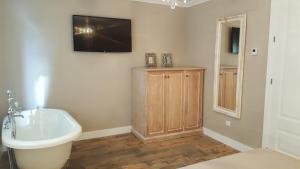 a bathroom with a sink and a tv on the wall at Casa Rural Rojo del Tietar in La Iglesuela +152 photos