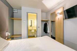 B&B HOTEL Bourges 2 في بورج: غرفة نوم بسرير ابيض وحمام