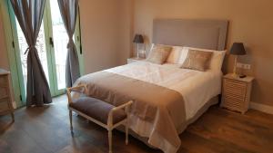 a bedroom with a large bed and a chair at Casa Rural Rojo del Tietar in La Iglesuela