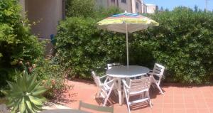 a table and chairs with an umbrella on a patio at Casa Giummarra al primo piano in San Vito lo Capo