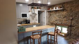 a kitchen with a counter and some chairs in it at Casa Rural Rojo del Tietar in La Iglesuela