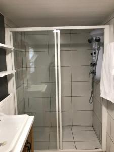 a shower with a glass door in a bathroom at A Casa do Avô Coelho in Santo Antão