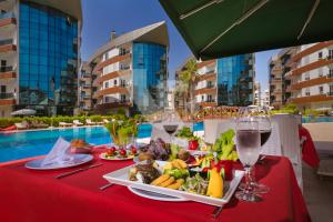Onkel Rada Apart Hotel في أنطاليا: طاولة مع طبق من الطعام وكؤوس من النبيذ