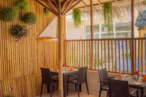 a restaurant with a table and chairs and a large window at Sandy Heaven Maldives in Gulhi