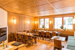 ein Restaurant mit Holzwänden sowie Holztischen und -stühlen in der Unterkunft Hotel Waldhorn in Kempten