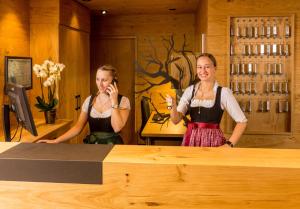 dos chicas en un bar hablando por sus celulares en Hotel Waldhorn en Kempten