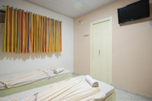 a hospital room with two beds and a television at Mirage Motel Guarulhos in São Paulo