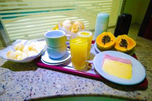 a tray with food and drinks on a table at Mirage Motel Guarulhos in São Paulo