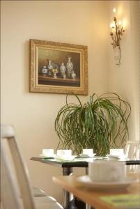 een tafel met een plant en een foto aan de muur bij Château De Lazenay - Résidence Hôtelière in Bourges