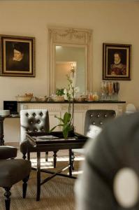 a living room with a table and a mirror at Château De Lazenay - Résidence Hôtelière in Bourges