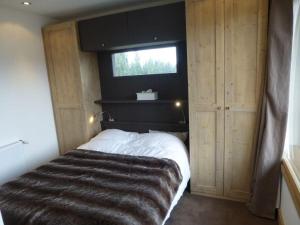 een slaapkamer met een groot bed met een raam bij Nogentil in Saint-Bon-Tarentaise