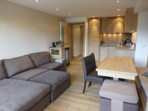 een woonkamer met een bank en een tafel en een keuken bij Nogentil in Saint-Bon-Tarentaise
